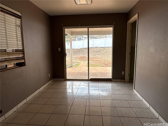 spare room with baseboards and light tile patterned floors