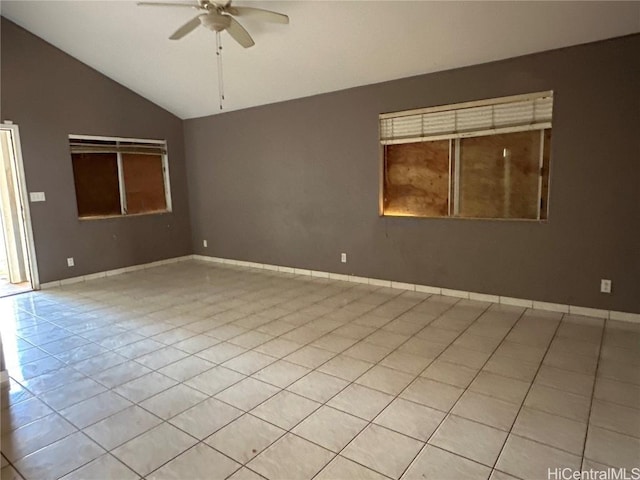 empty room featuring light tile patterned floors, vaulted ceiling, a ceiling fan, and baseboards