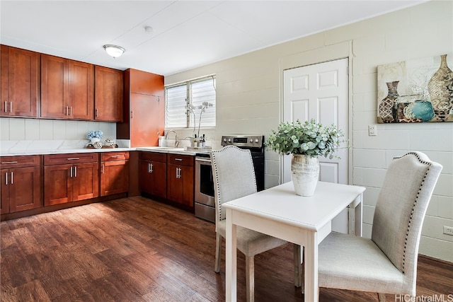 kitchen featuring dark wood-style floors, light countertops, stainless steel electric range oven, and a sink