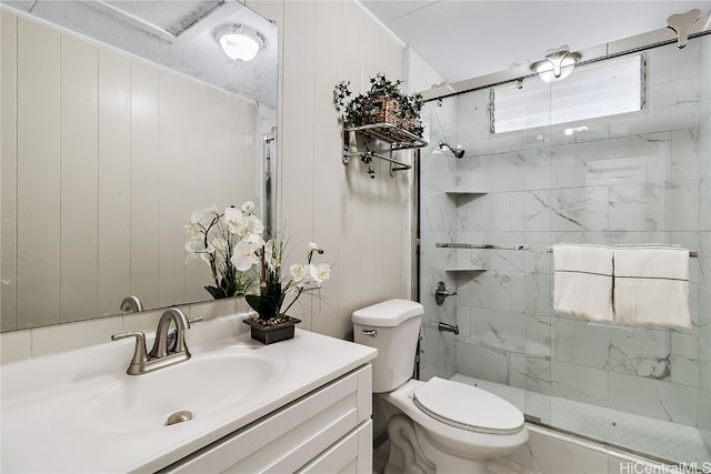 full bathroom with vanity, a shower stall, and toilet