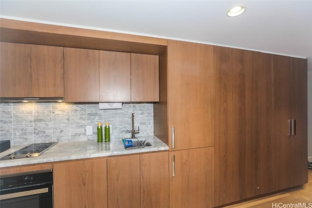 2139 Kuhio Ave Unit 1207, Honolulu, HI 96815 - kitchen featuring decorative backsplash, modern cabinets, light stone countertops, black appliances, and a sink