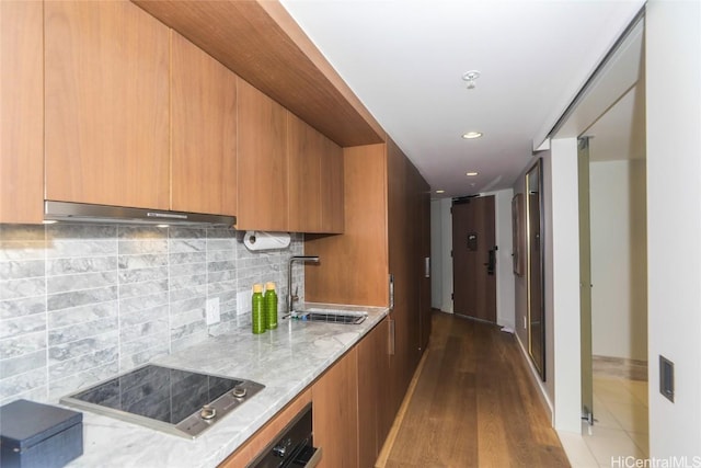 2139 Kuhio Ave Unit 1207, Honolulu, HI 96815 - kitchen with modern cabinets, a sink, under cabinet range hood, and black electric cooktop