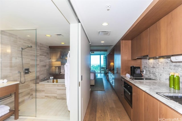 2139 Kuhio Ave Unit 1207, Honolulu, HI 96815 - kitchen with brown cabinetry, visible vents, black appliances, and modern cabinets