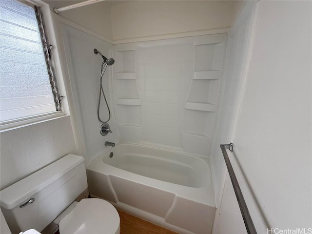 bathroom with a healthy amount of sunlight, toilet, and bathing tub / shower combination