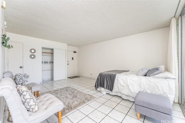 bedroom featuring light tile patterned floors, a closet, and a textured ceiling