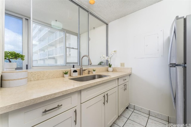 bathroom with baseboards, a textured ceiling, and vanity