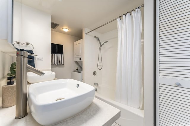 bathroom with a closet, stacked washer and clothes dryer, visible vents, and shower / tub combo with curtain