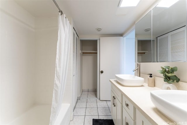 full bathroom featuring a sink, tile patterned flooring, double vanity, and a closet