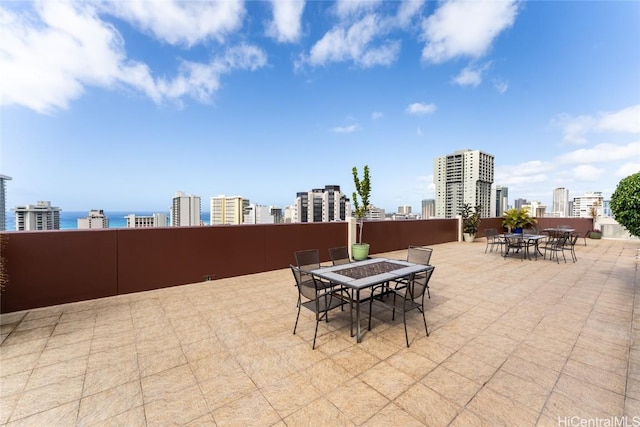 view of patio / terrace featuring outdoor dining area, a water view, and a city view