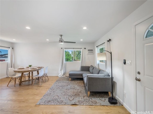 living room featuring light wood-style flooring, recessed lighting, a ceiling fan, baseboards, and a wall mounted AC