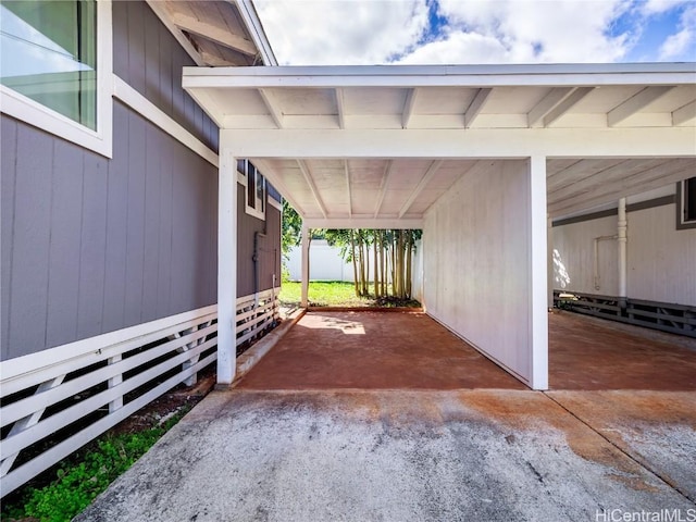 view of car parking featuring fence and a carport