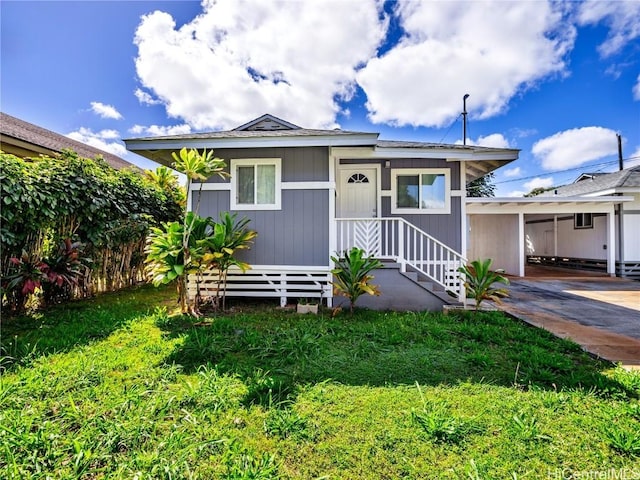 bungalow-style house with an attached carport, concrete driveway, and a front yard