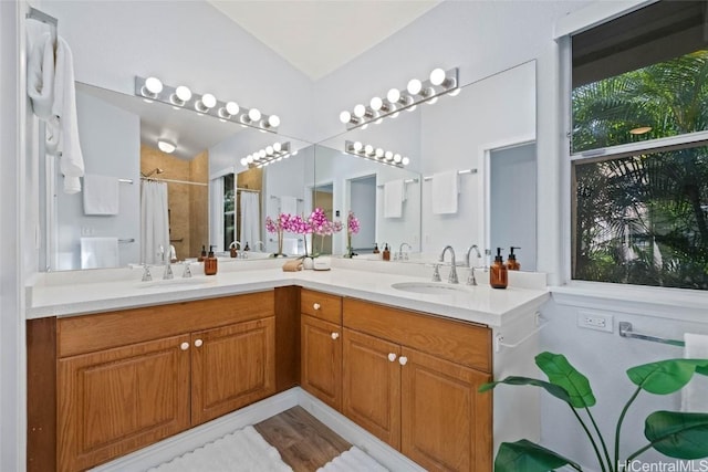 full bath with vaulted ceiling, a sink, a shower with shower curtain, and double vanity