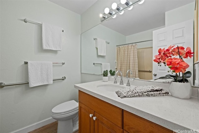 bathroom with baseboards, a shower with shower curtain, toilet, wood finished floors, and vanity