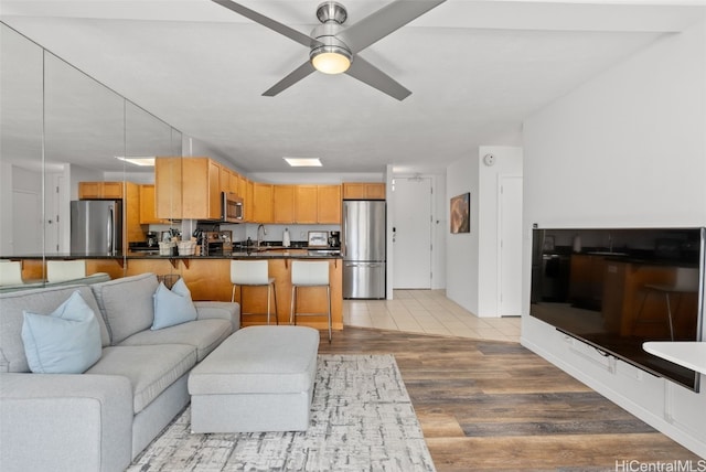 living room with ceiling fan and wood finished floors