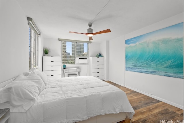 bedroom with dark wood-type flooring, a ceiling fan, and baseboards