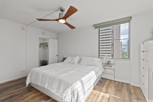 bedroom with dark wood-style floors, multiple windows, and baseboards