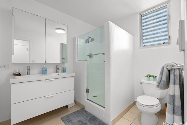 full bathroom with double vanity, baseboards, tile patterned flooring, a shower stall, and a sink