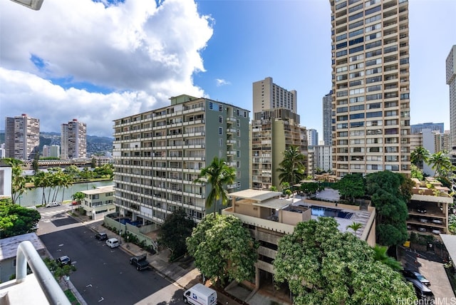 view of building exterior featuring a water view and a city view