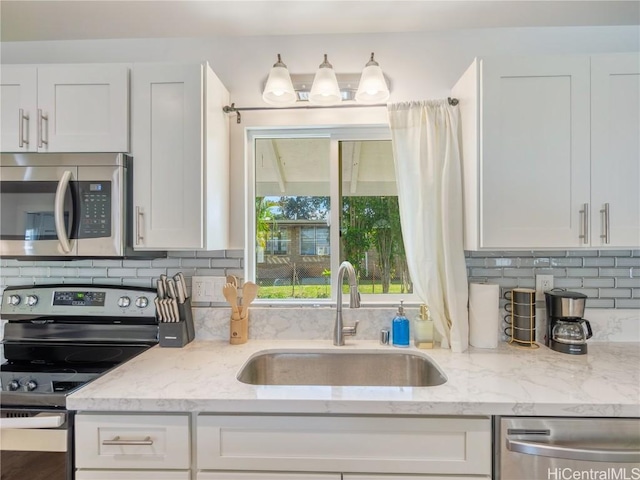 14 Hauola St, Wahiawa, HI 96786 - kitchen with appliances with stainless steel finishes, light stone counters, a sink, white cabinetry, and backsplash