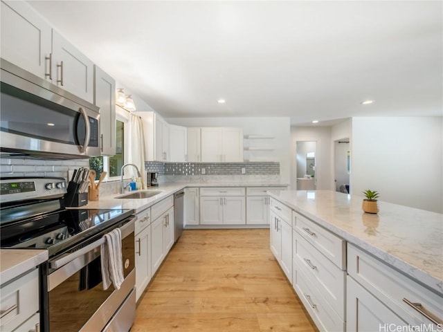 14 Hauola St, Wahiawa, HI 96786 - kitchen featuring light wood finished floors, white cabinets, stainless steel appliances, open shelves, and a sink