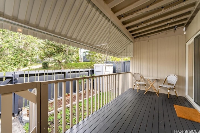 wooden terrace featuring an outdoor structure and a storage shed