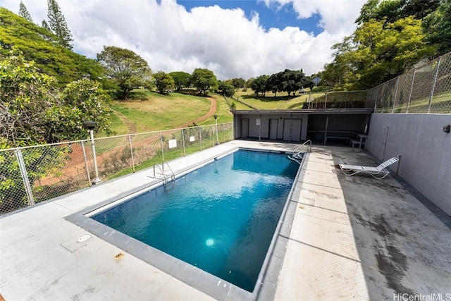 pool with a patio area and fence