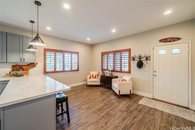 foyer with baseboards, dark wood finished floors, and recessed lighting