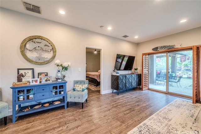 sitting room featuring baseboards, wood finished floors, visible vents, and recessed lighting