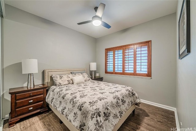 bedroom featuring dark wood-style floors, ceiling fan, and baseboards