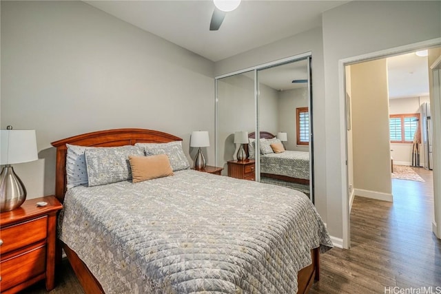 bedroom with a closet, dark wood-style flooring, baseboards, and a ceiling fan