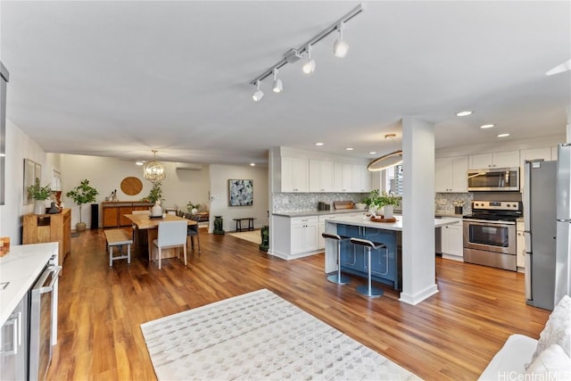 living room featuring light wood finished floors, a chandelier, and recessed lighting