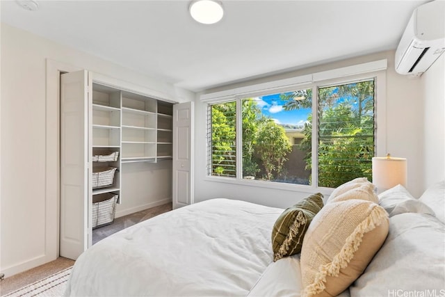 bedroom featuring a closet, a wall mounted AC, carpet flooring, and baseboards