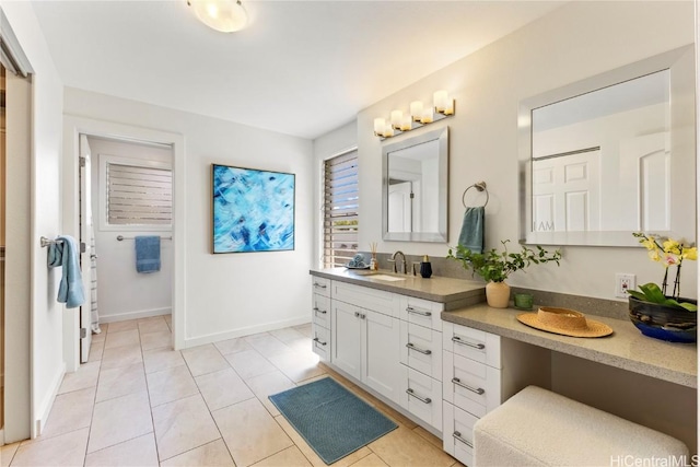 bathroom with vanity, baseboards, and tile patterned floors