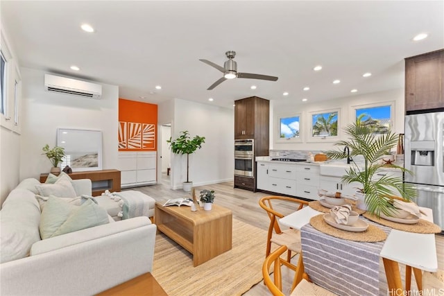 living room with light wood finished floors, recessed lighting, ceiling fan, and a wall mounted AC