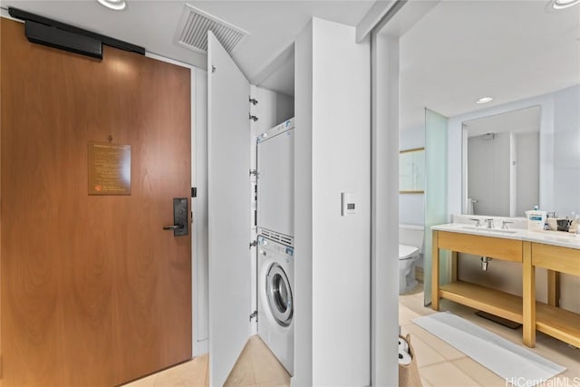 washroom featuring light tile patterned floors, recessed lighting, laundry area, stacked washer / dryer, and visible vents