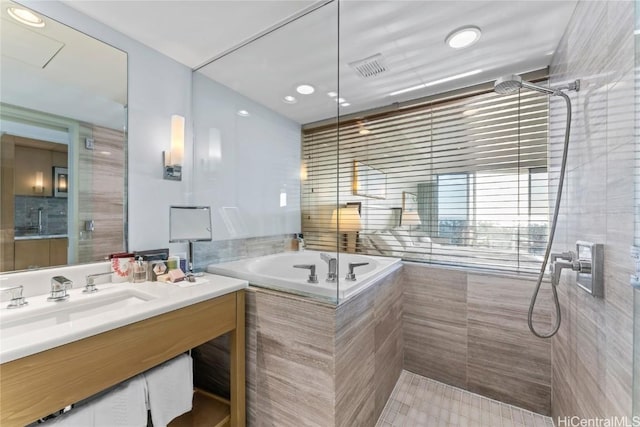 full bathroom with visible vents, tiled shower, a garden tub, and vanity