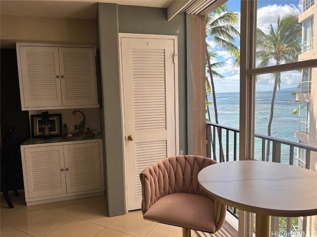 dining area with light tile patterned floors and a water view