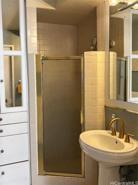 bathroom with a sink and a shower stall