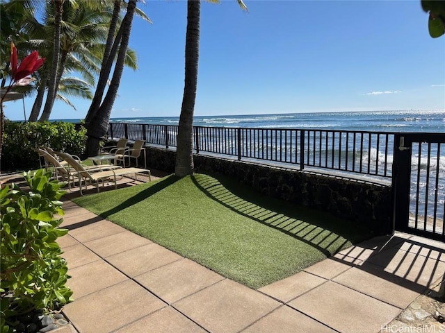 view of yard featuring a patio, a water view, and fence