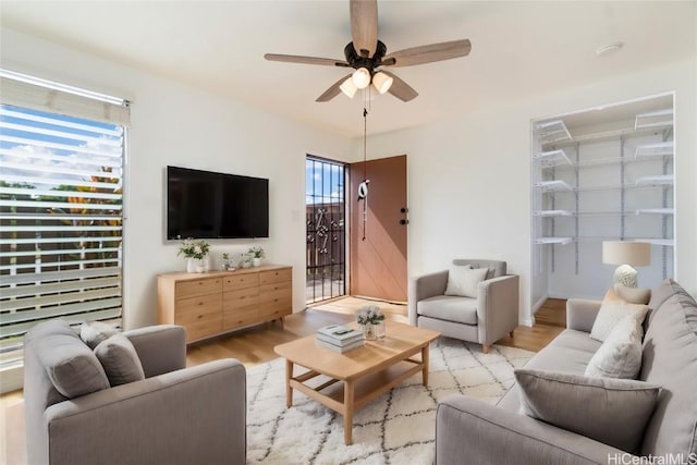 living room with light wood-style floors and a ceiling fan