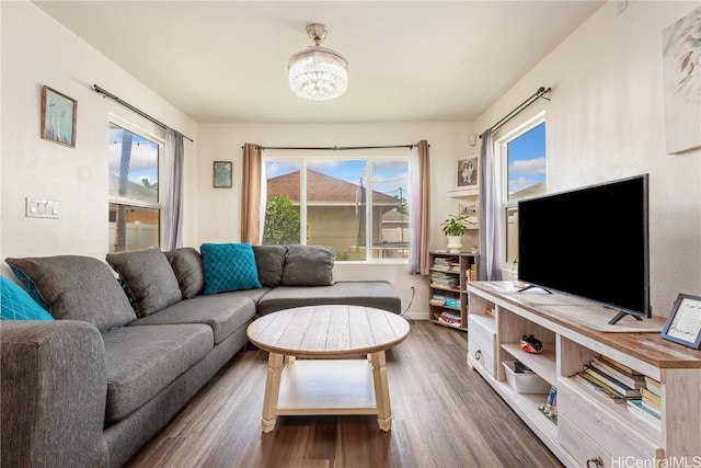 living room featuring dark wood-type flooring and a notable chandelier