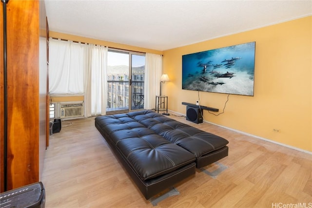 living area featuring baseboards, cooling unit, and light wood-style floors