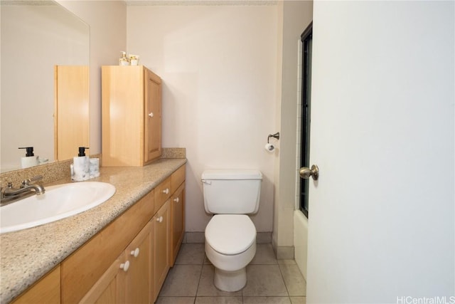 bathroom with baseboards, toilet, enclosed tub / shower combo, tile patterned flooring, and vanity