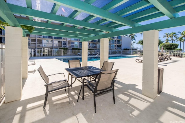 view of patio featuring a pergola, fence, and a community pool