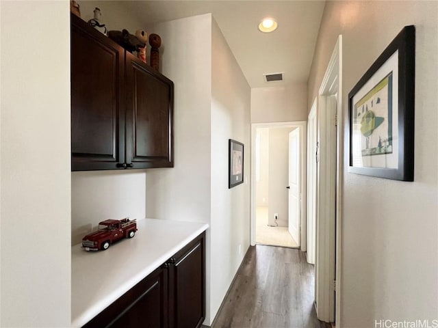 hallway featuring dark wood-type flooring, visible vents, and recessed lighting