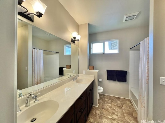 bathroom featuring toilet, visible vents, shower / bath combo with shower curtain, and a sink