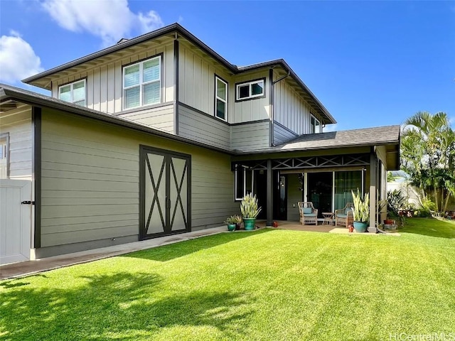 rear view of house with a yard, board and batten siding, and a patio