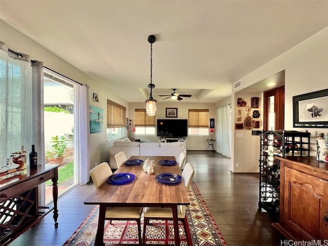 dining space with dark wood-type flooring, visible vents, and a ceiling fan