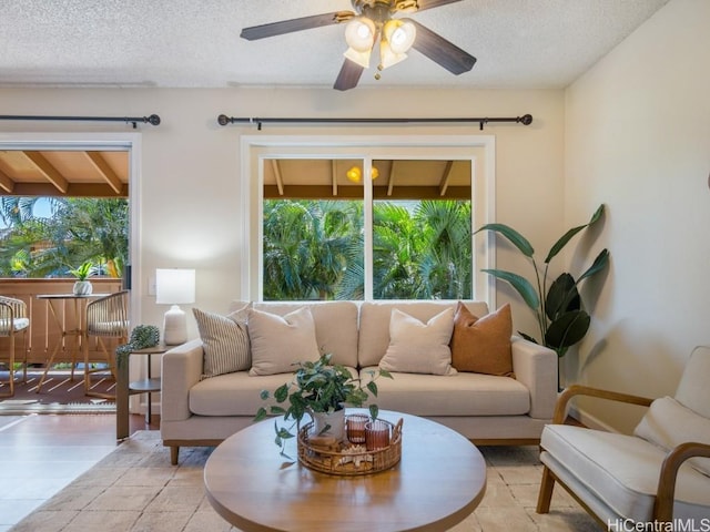 living area with a textured ceiling and a ceiling fan